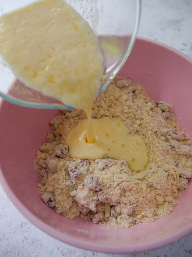 Dry scone ingredients in a bowl with a mixture of beaten egg and buttermilk being added.