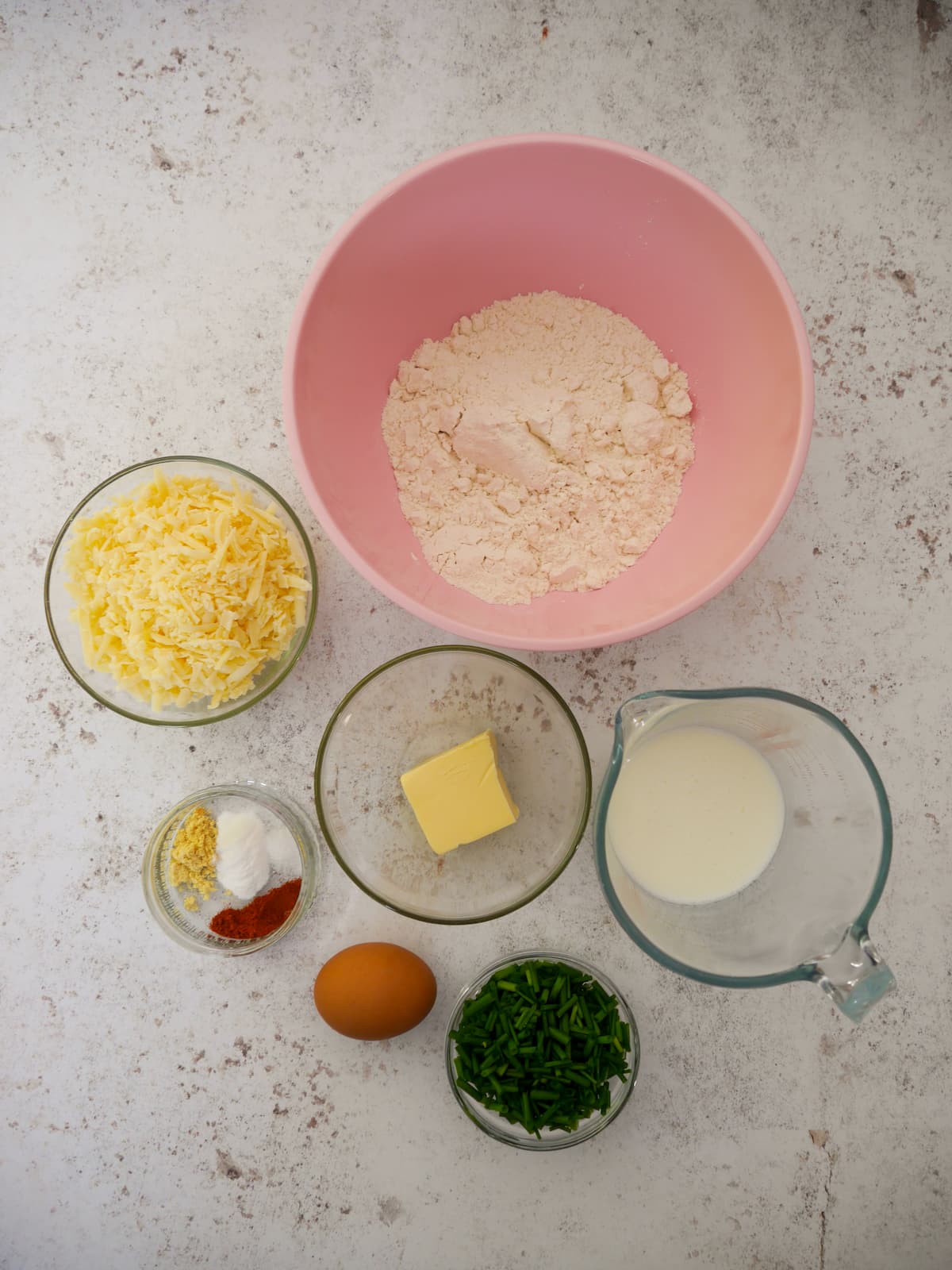 Individual recipe ingredients for cheese and chive scones.