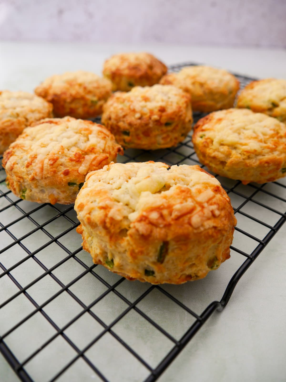 A wire cooling rack topped with 9 cheese and jalapeno scones.