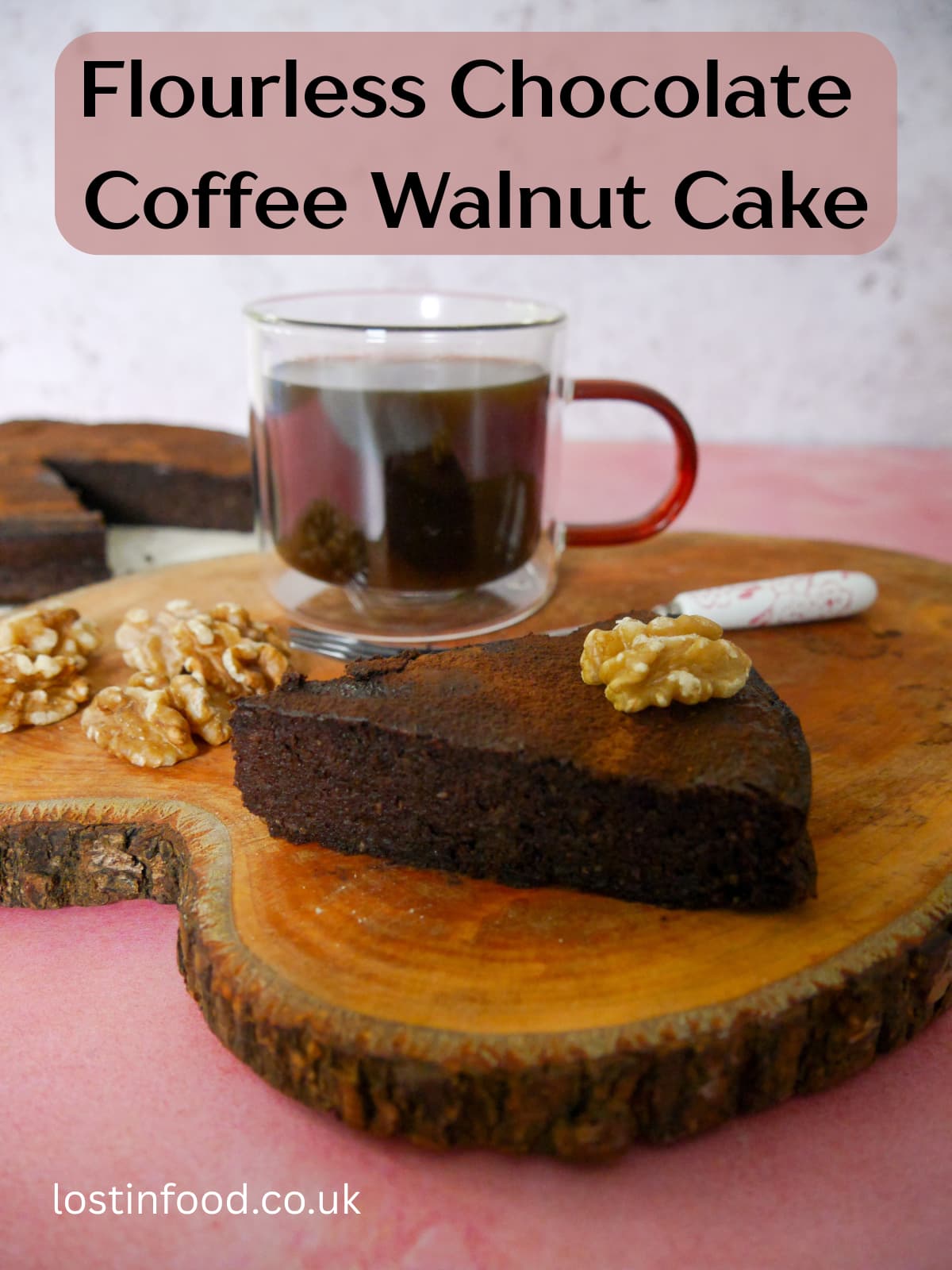 Pinnable image with recipe title and image of a slice of flourless chocolate coffee walnut cake served with a glass mug of coffee, set on a wooden board, with the whole cake set alongside.