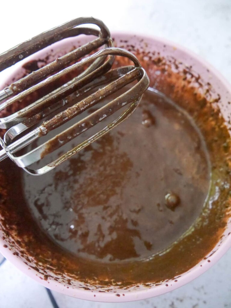 A bowl of whisked eggs and sugar with added melted butter beaten through.