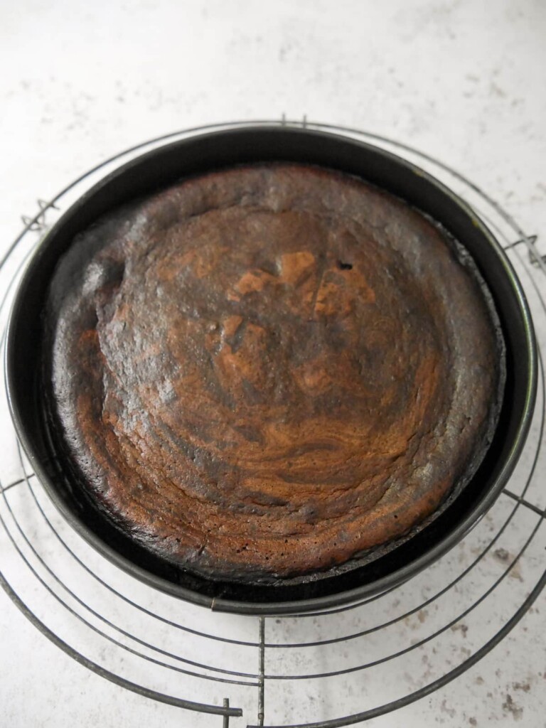 Flourless chocolate coffee walnut cake cooling in the tin and set on a wire rack.