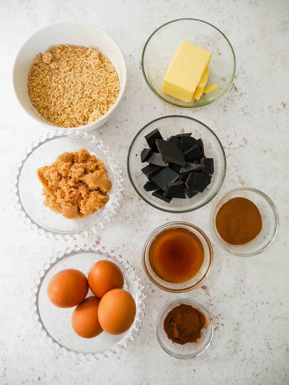 Individual recipe ingredients for flourless chocolate, coffee and walnut cake.