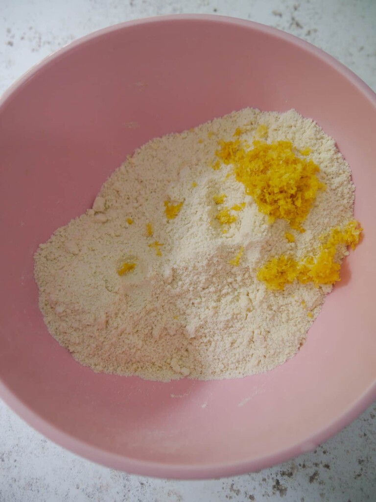 Dry scone recipe ingredients rubbed together, with finely grated lemon zest being added.