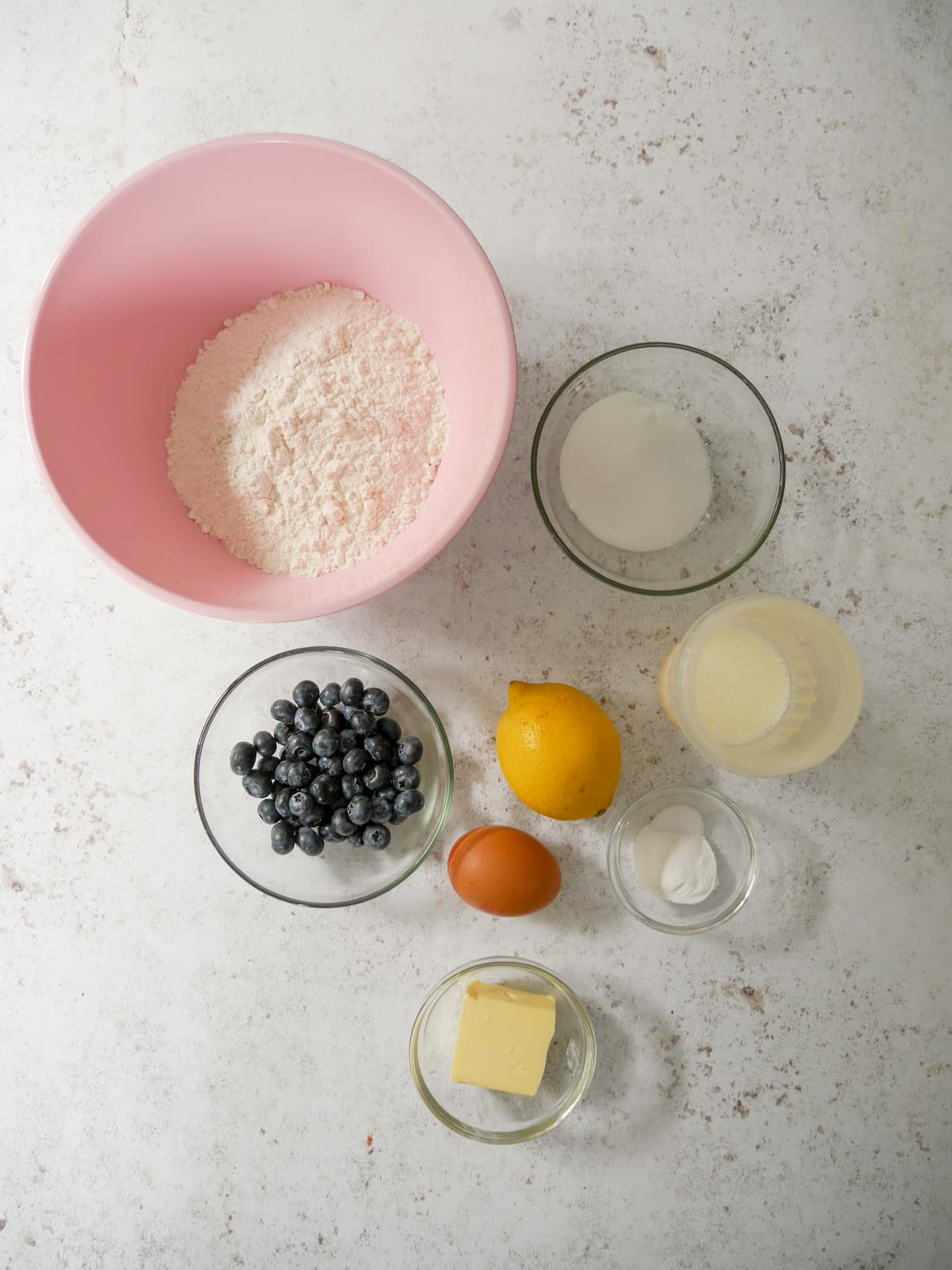 Individual recipe ingredients for lemon and blueberry scones.