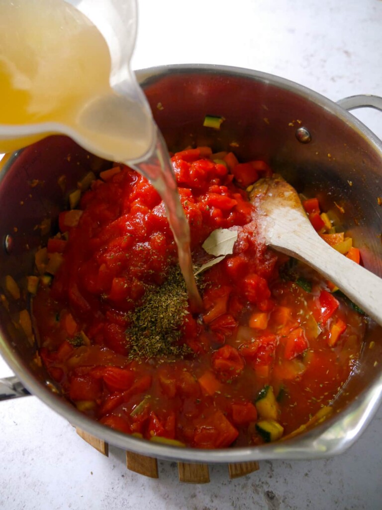 Sauteed vegetables and spiced with chopped tomatoes, dried herbs and chicken stock being added.