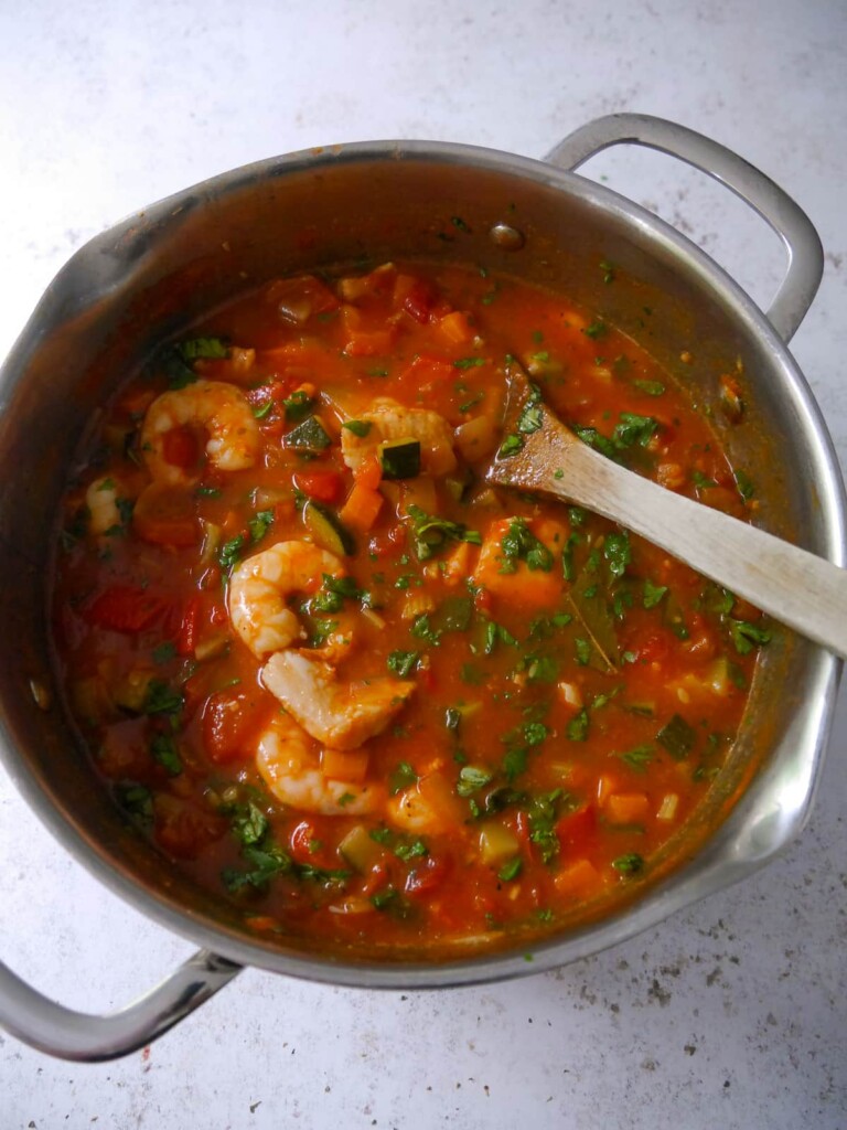 A large soup pan filled with cooked Mediterranean fish soup.