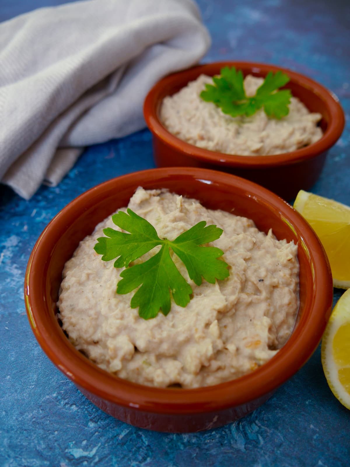 2 bowls of smoked mackerel pate with wedges of lemon set alongside.