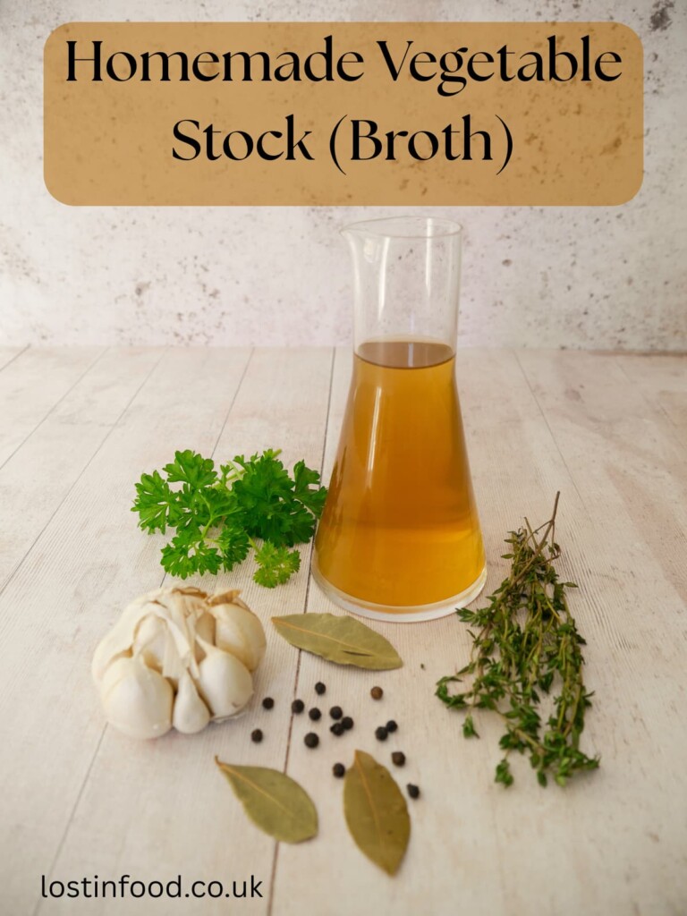 Pinnable image with recipe title and a jug of homemade vegetable stock, with fresh herbs and aromatics set alongside.