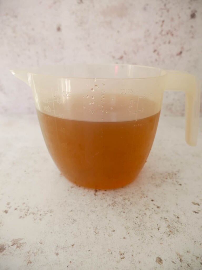 A large jug of freshly made vegetable broth.