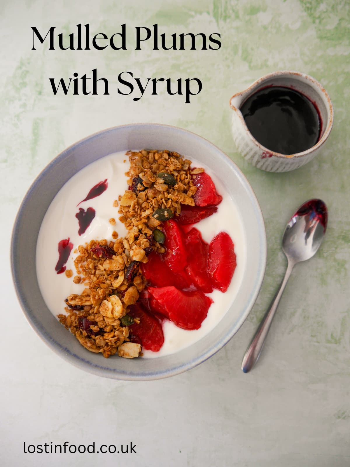Pinnable image with recipe title with a bowl of Greek yogurt topped with mulled plums and granola, with a jug of mulled plum syrup set alongside.