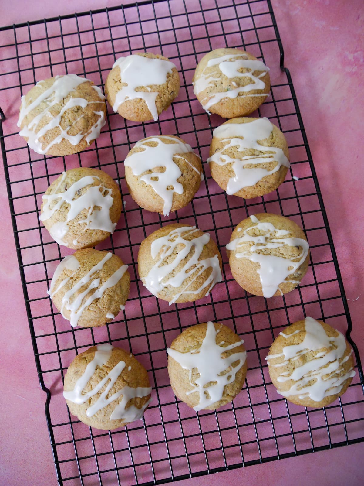 A wire rack of pistachio and lemon cookies topped with a lemon glaze.