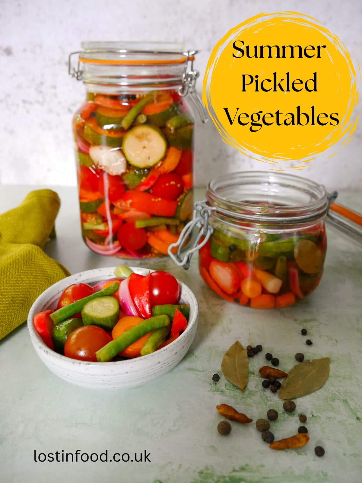 Pinnable image with recipe title and jars of summer pickled vegetables with a bowl of vegetables and some dry spices set alongside.