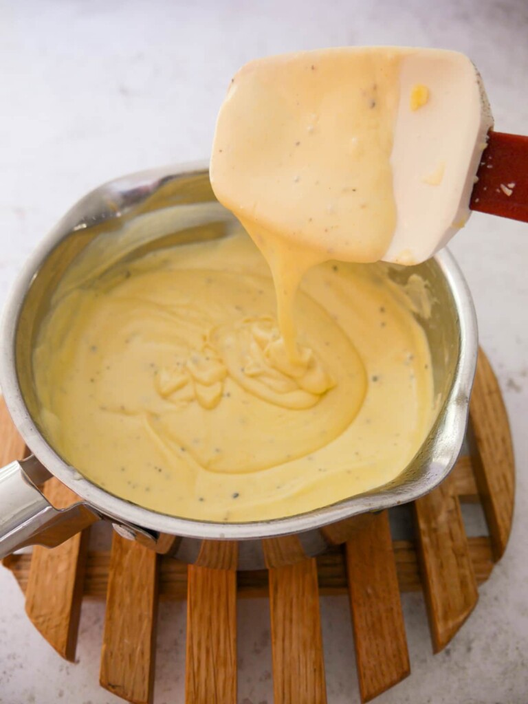 A small saucepan with a creamy mustard and cheese sauce.