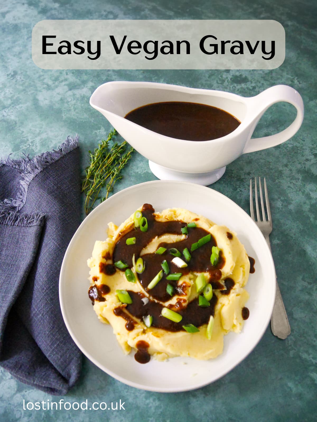 Pinnable image with recipe title with a bowl of creamy mashed potatoes topped with vegan gravy and garnished with sliced green onions, with a gravy boat of gravy set alongside.