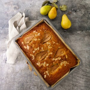 A baking tray filled with a baked pear and almond cake.