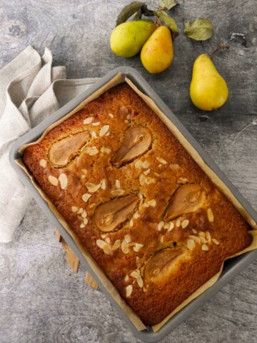 A baking tray filled with a baked pear and almond cake.