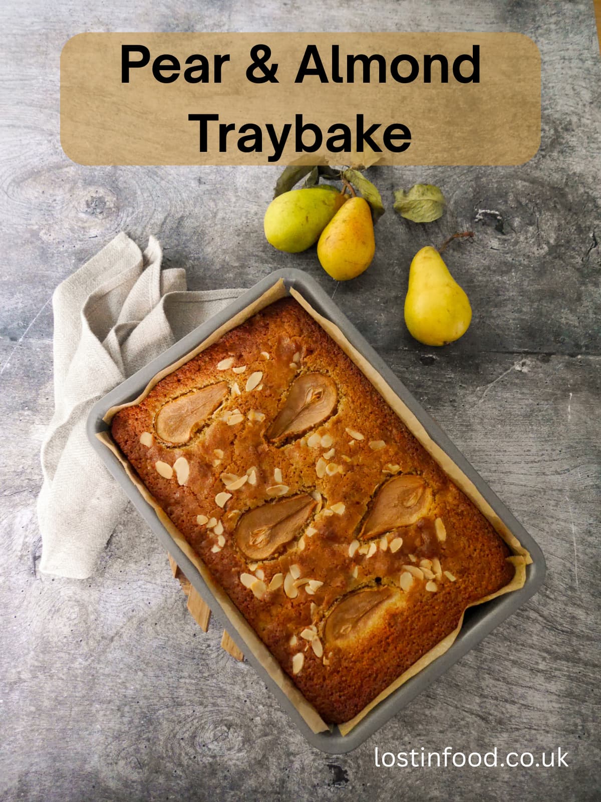 Pinnable image with recipe title and a baking tray filled with a baked pear and almond cake.