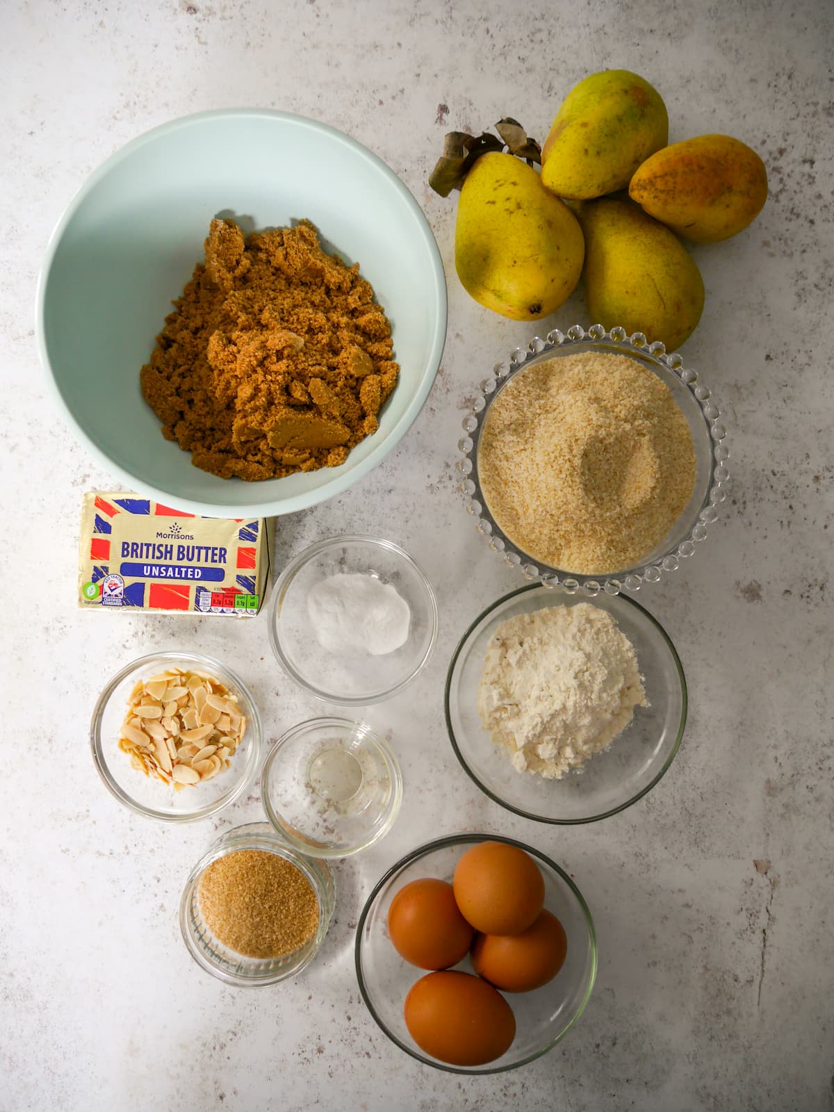 Individual recipe ingredients for making pear and almond traybake.