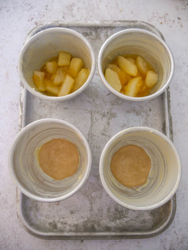 4 individual pudding bowls, greased and lined with baking paper, set on a baking tray.