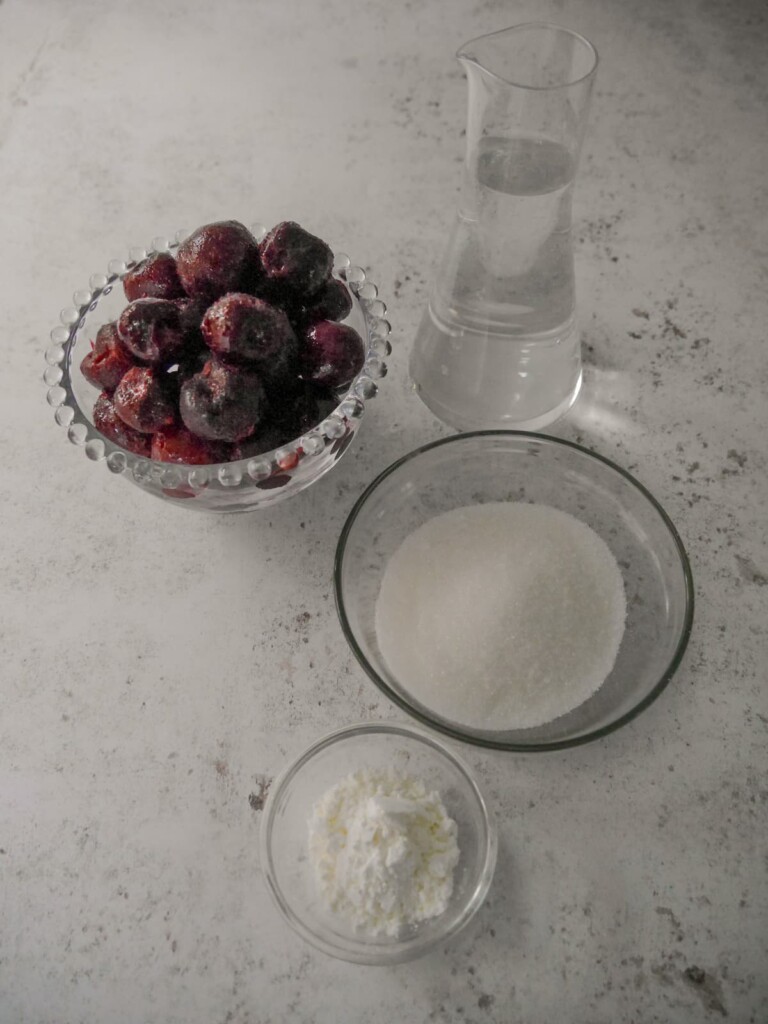 Individual recipe ingredients for making dark cherry compote.
