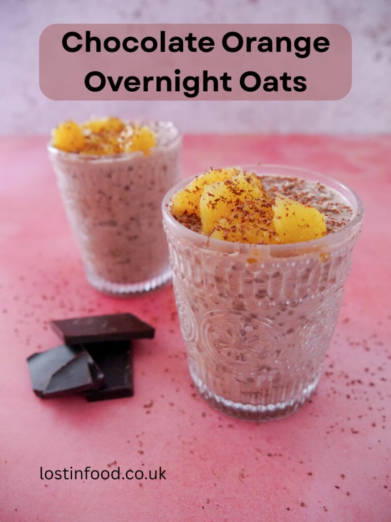 Pinnable image with recipe title and two glasses filled with chocolate orange overnight oats, topped with orange segments and grated dark chocolate.