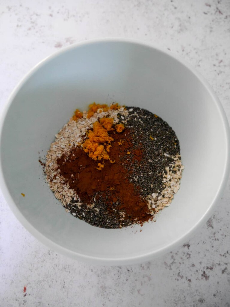 A bowl of porridge oats (rolled oats) with added cocoa powder, grated orange zest and chia seeds.