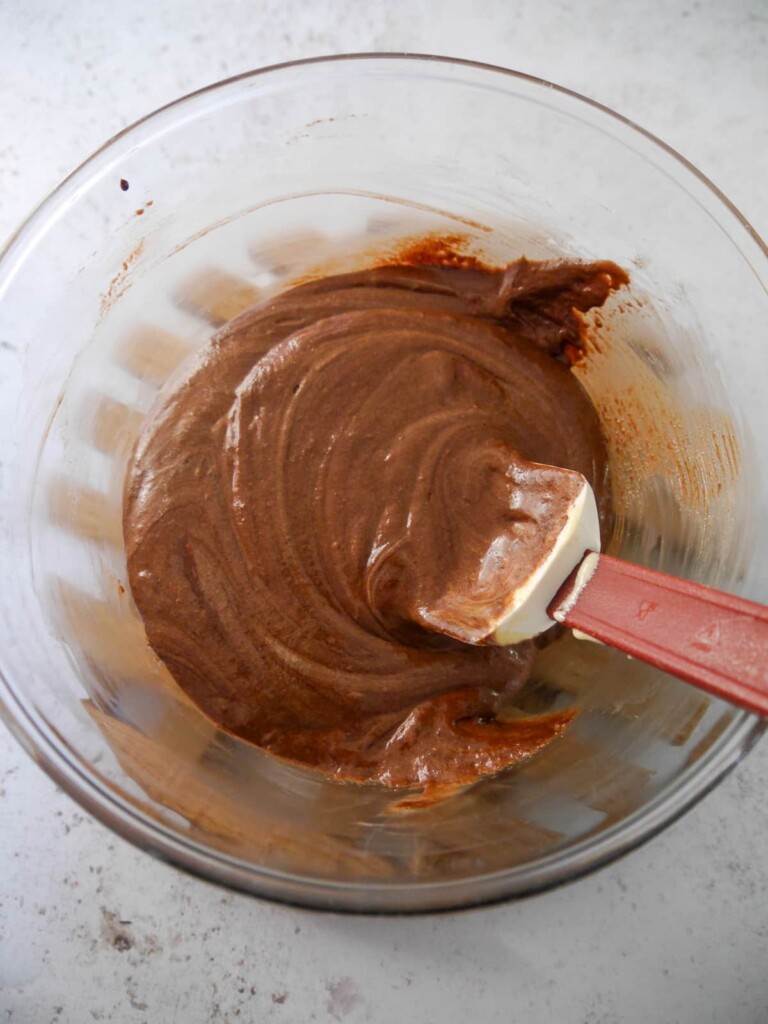 A bowl of combined melted dark chocolate, with whipped egg yolks and sugar.