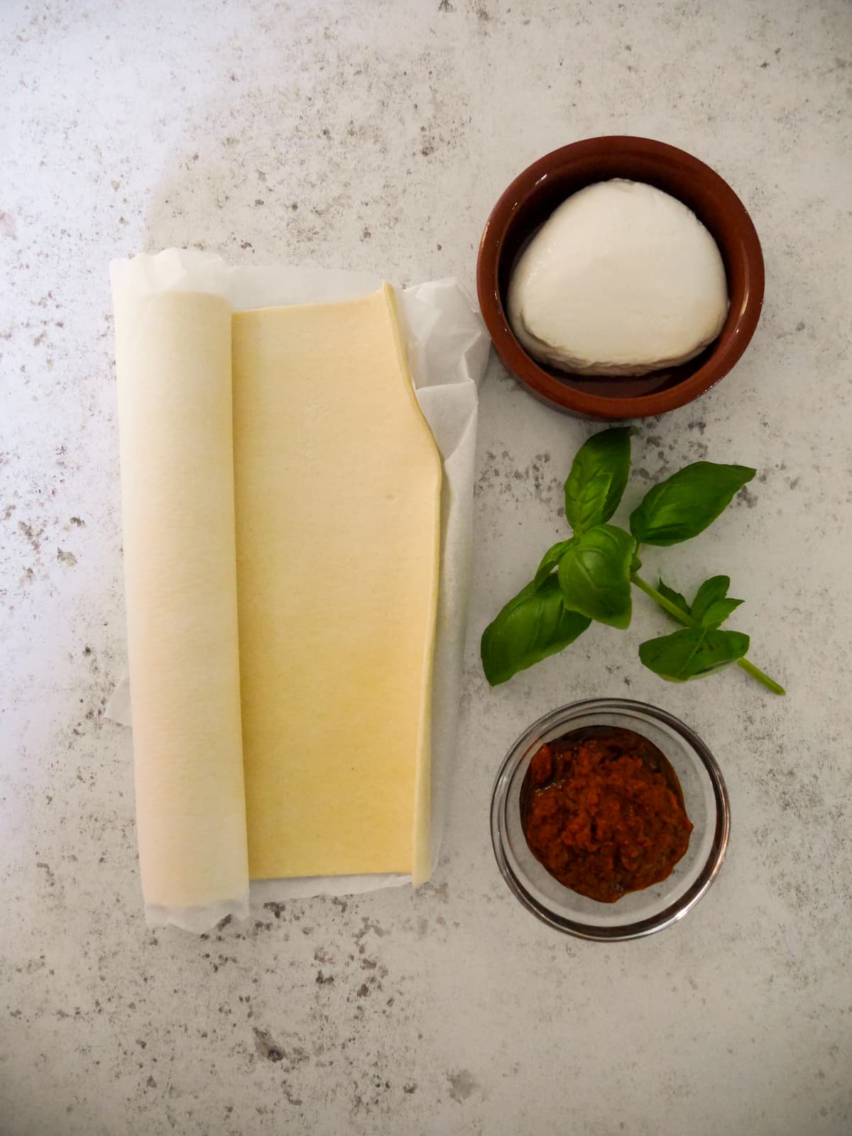 Individual recipe ingredients for red pesto pinwheels with puff pastry.