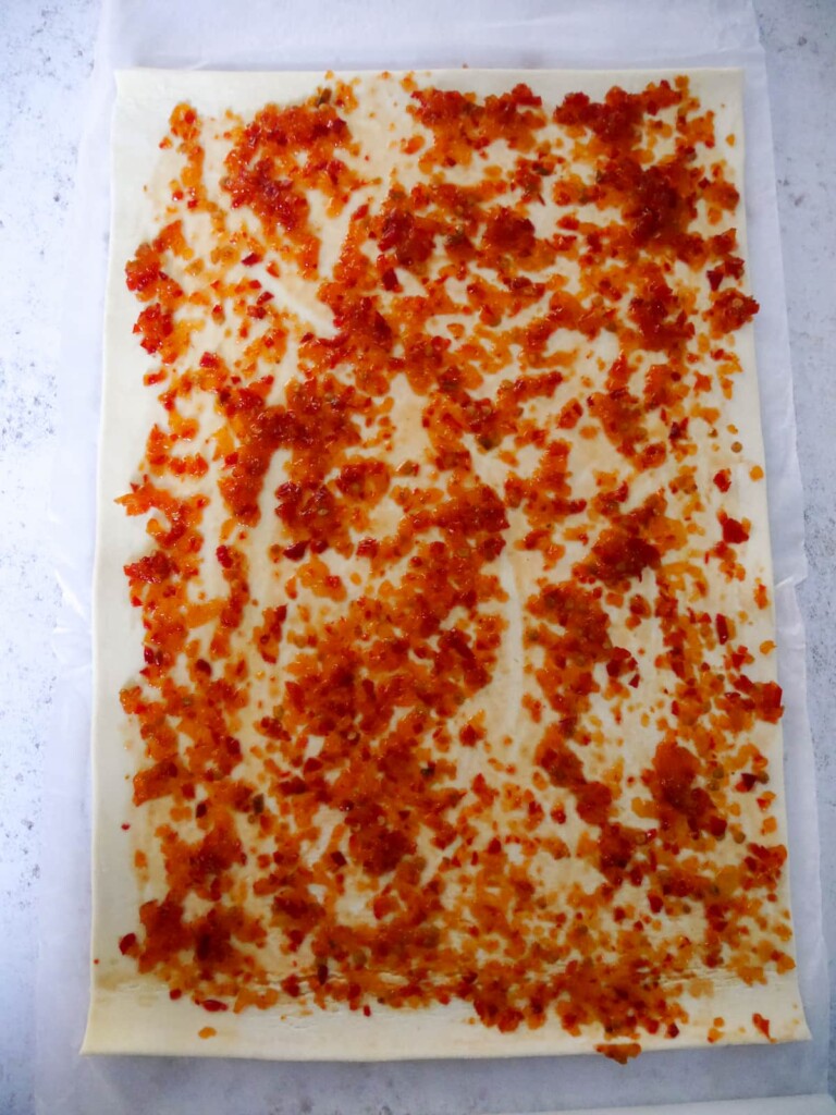 A sheet of puff pastry topped with a thin layer of chilli jam.