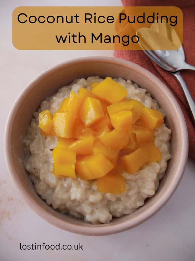 Pinnable image with recipe title and a bowl of coconut rice pudding topped with chopped mango.