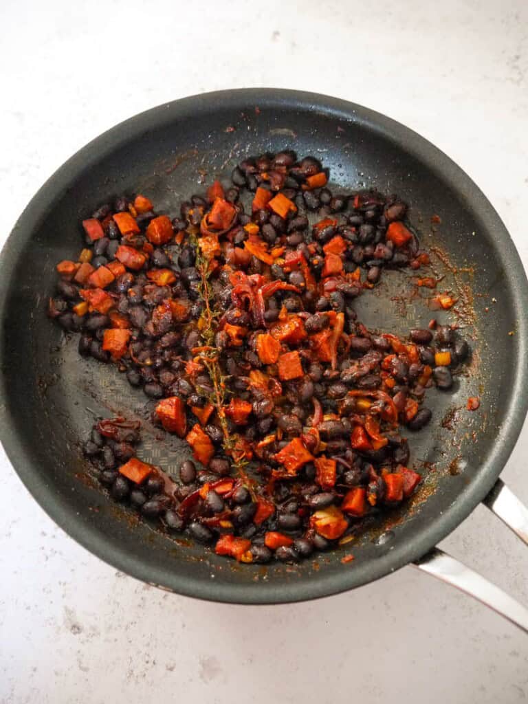 A saucepan of cooked black beans and chorizo.