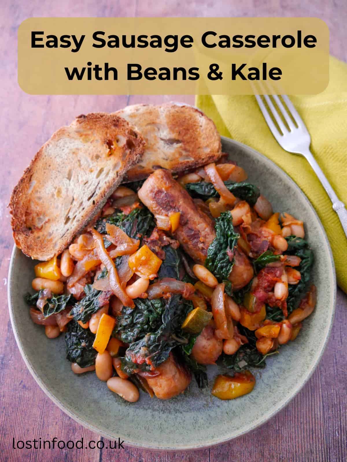 Pinnable image with recipe title and a bowl of sausage casserole with added cannellini beans and cavolo nero kale, served with toasted bread.