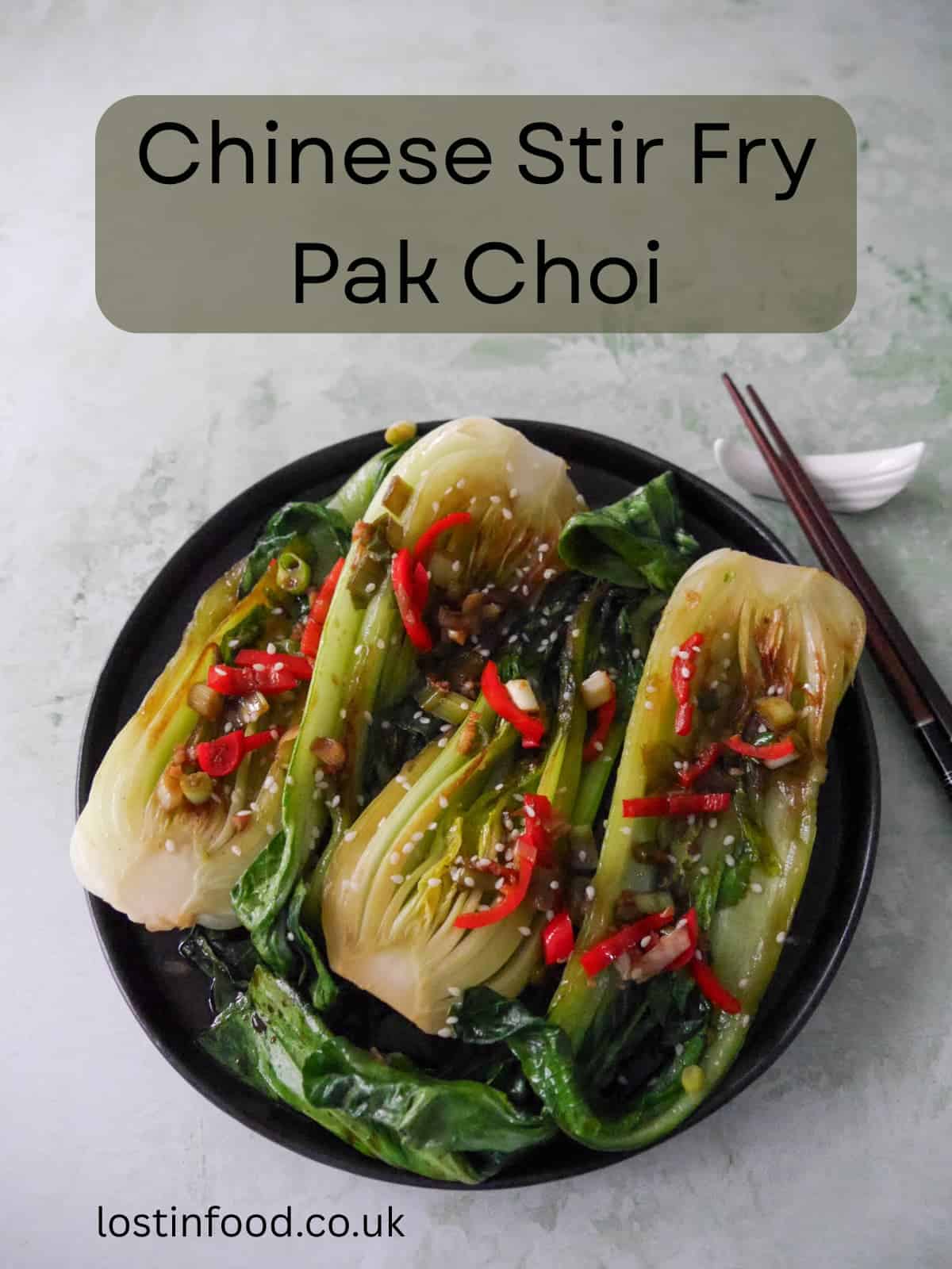 Pinnable image with recipe title and a plate of Chinese stir fry pak choi with garlic, red chillies and spring onion, garnished with sesame seeds.
