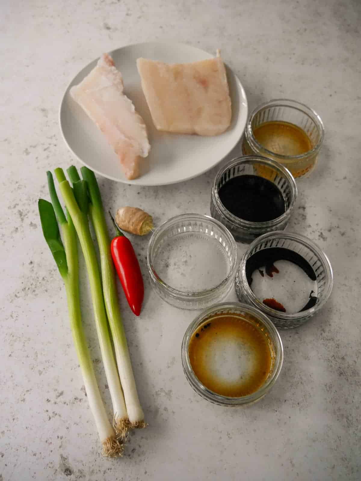Individual recipe ingredients for making Chinese steamed fish fillets.
