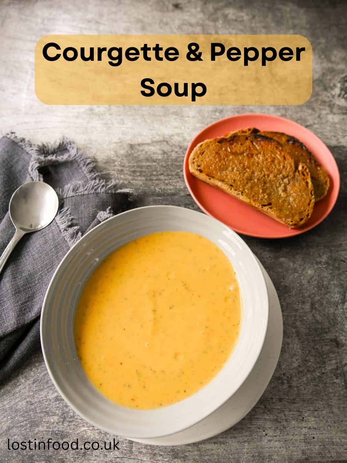 Pinnable image with recipe title and a bowl of courgette and pepper soup served with a side of toasted bread.