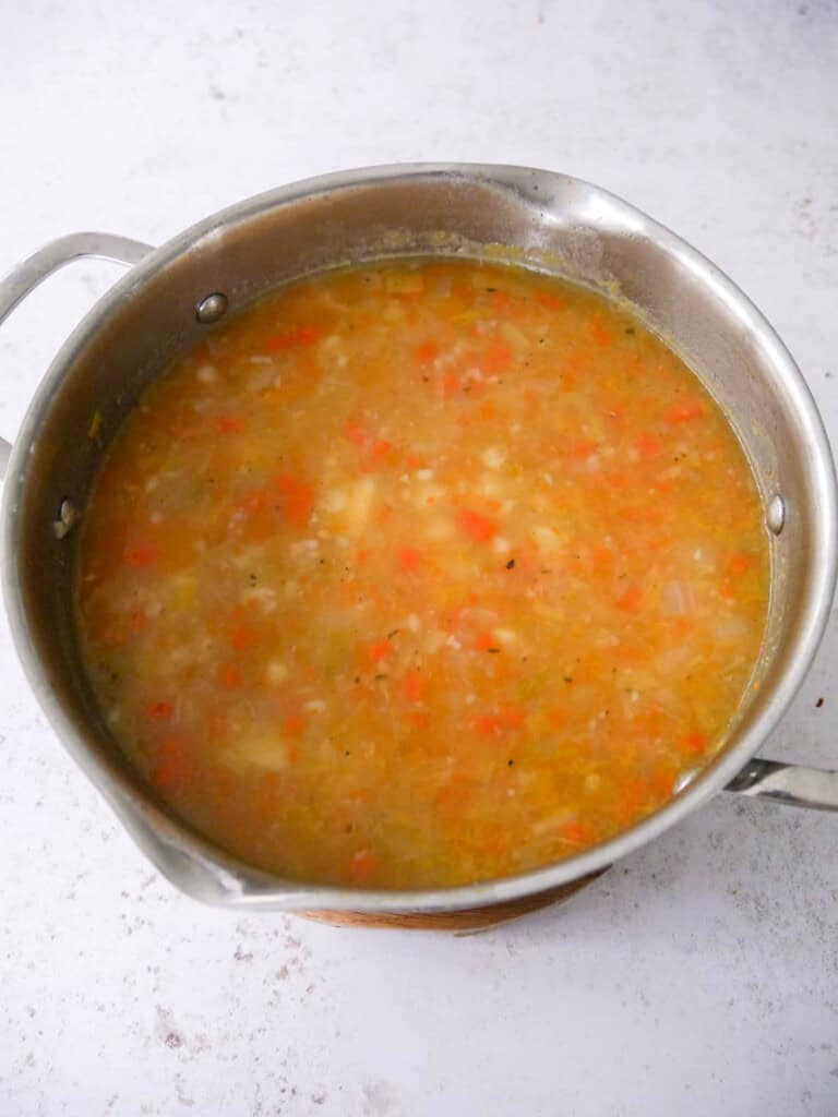 A large pan of potato and vegetable soup.