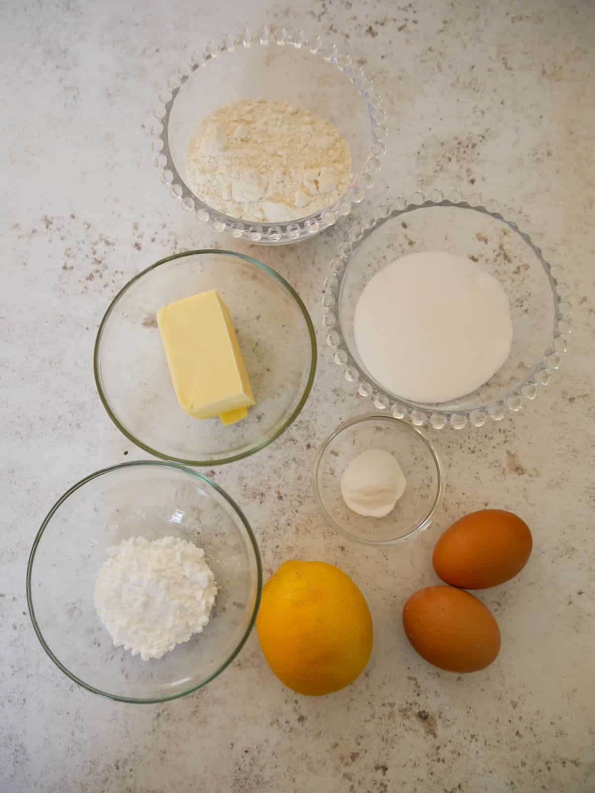 Individual recipe ingredients for making lemon madeleines.