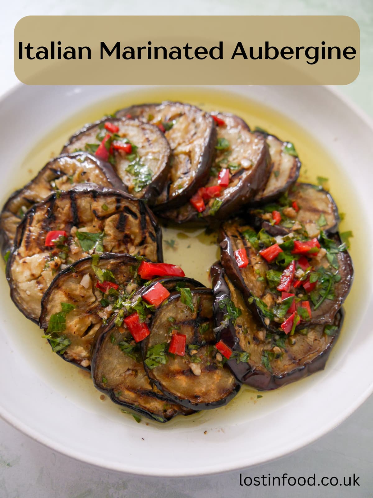 Pinnable image with recipe title and a bowl filled with Italian marinated aubergine slices.