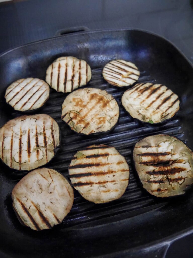A chargrill pan filled with slices of fresh aubergine.