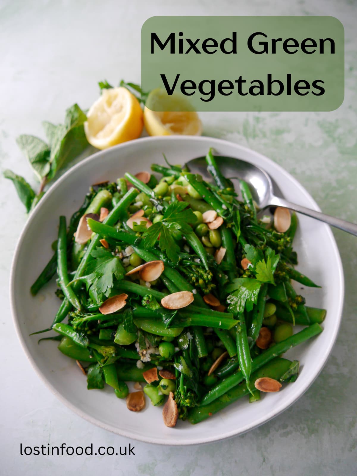 Pinnable image with recipe title and a bowl of mixed green vegetables including tenderstem broccoli, green beans, sugar snap peas, garden peas and edamame beans, coated with a garlic and herb butter with added toasted flaked almonds.