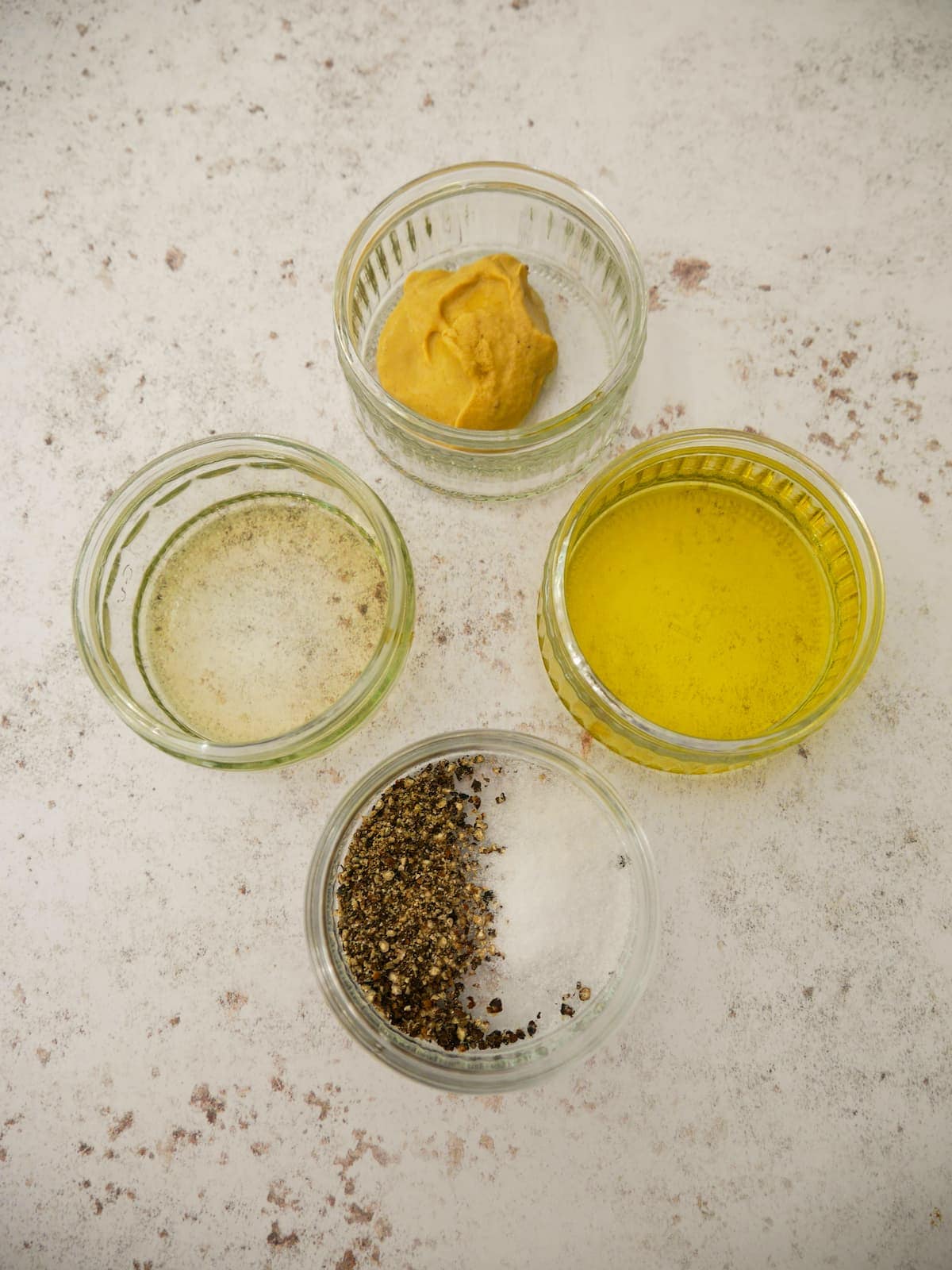 Individual recipe ingredients for making apple cider vinaigrette dressing.