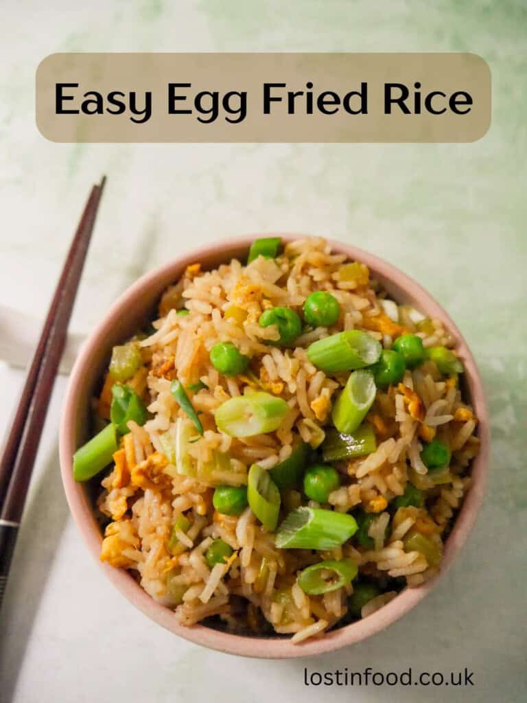 Pinnable image with recipe title and a bowl of egg fried rice, garnished with sliced spring onions.