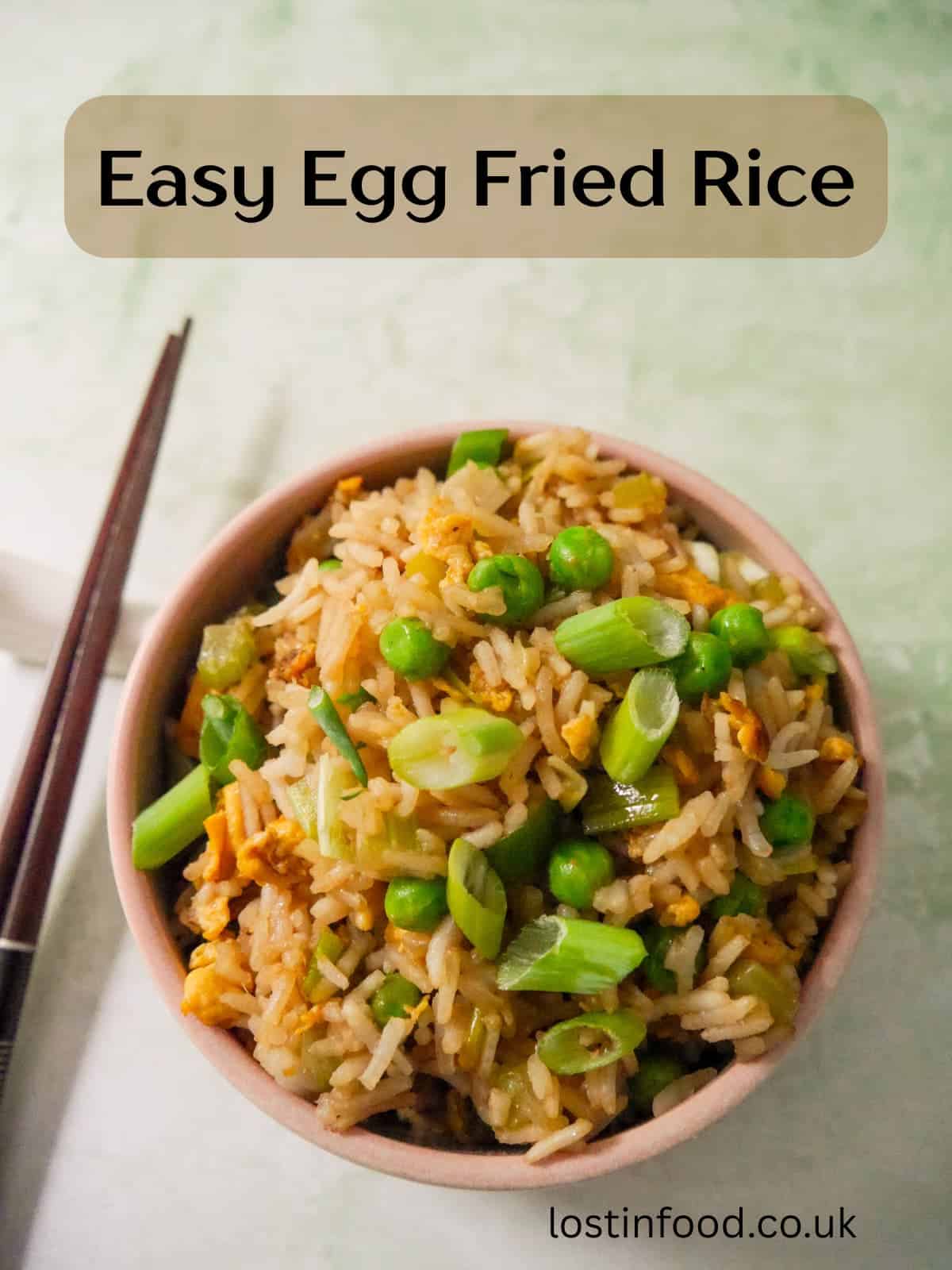 Pinnable image with recipe title and a bowl of egg fried rice, garnished with sliced spring onions.