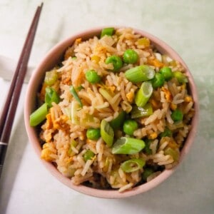 A bowl of egg fried rice, garnished with sliced spring onions.