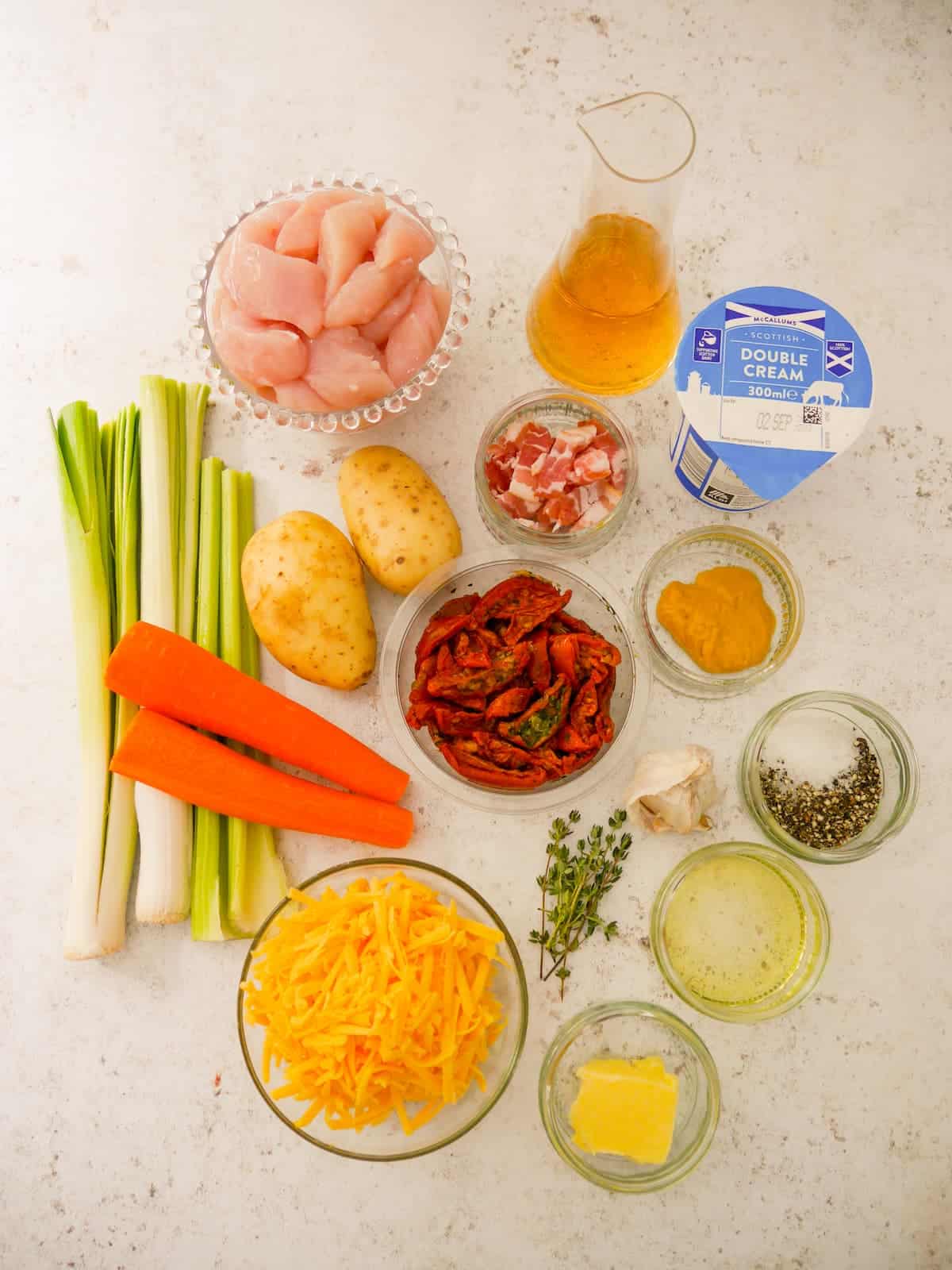 Individual recipe ingredients for making chicken and bacon bake in a creamy cider sauce.