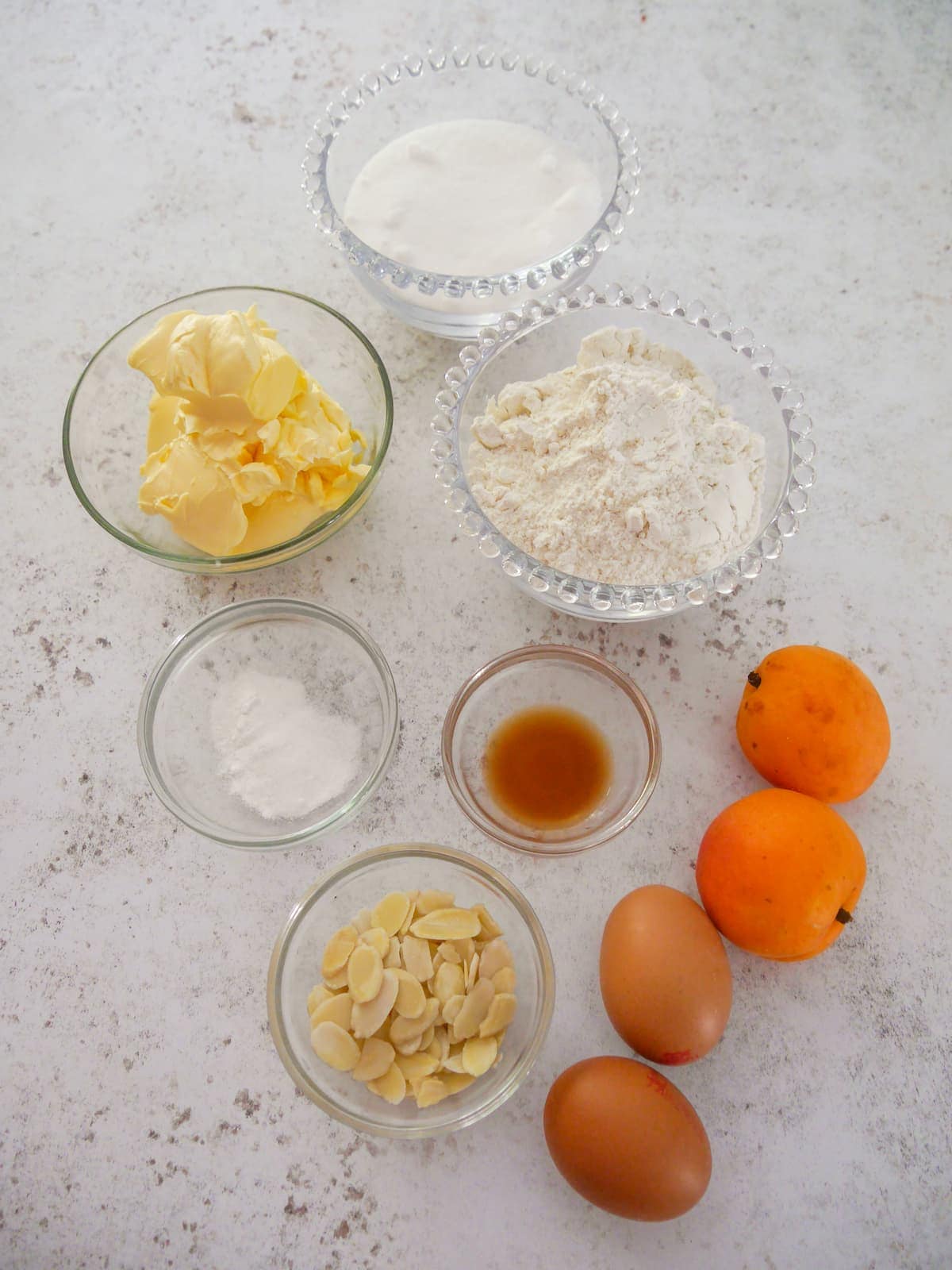 Individual recipe ingredients for making a fresh apricot sponge cake.